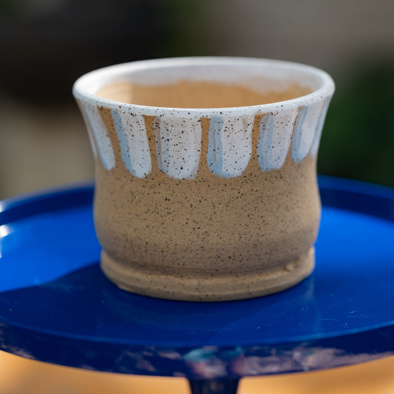 Ceramic plant pot with white and foggy blue accent lines around the rim